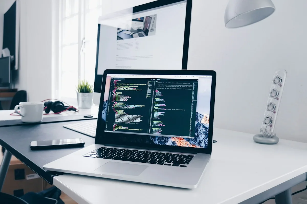 Un espacio de trabajo con un portátil y un teléfono mostrando paneles de automatización de tareas con IA